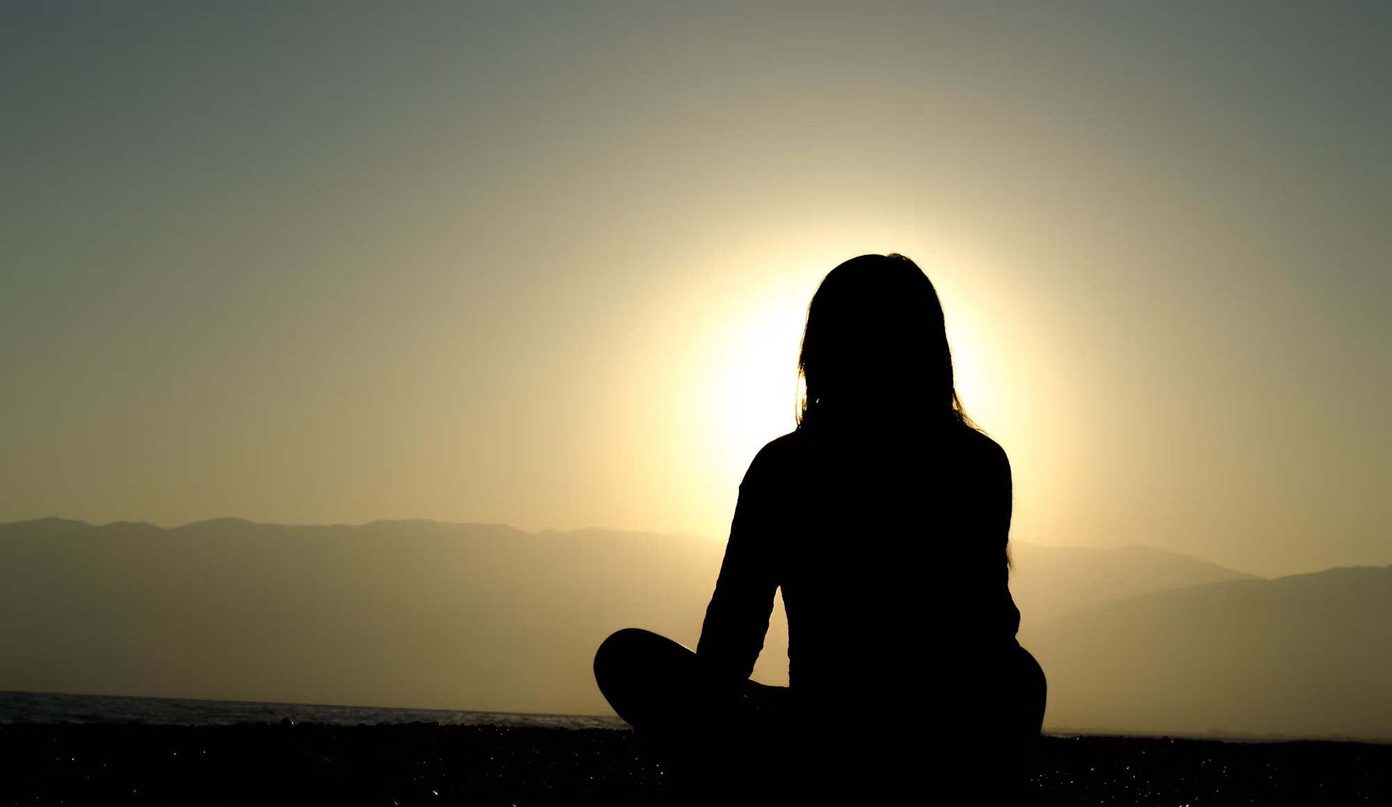 Person meditating with peaceful surroundings demonstrating mindfulness